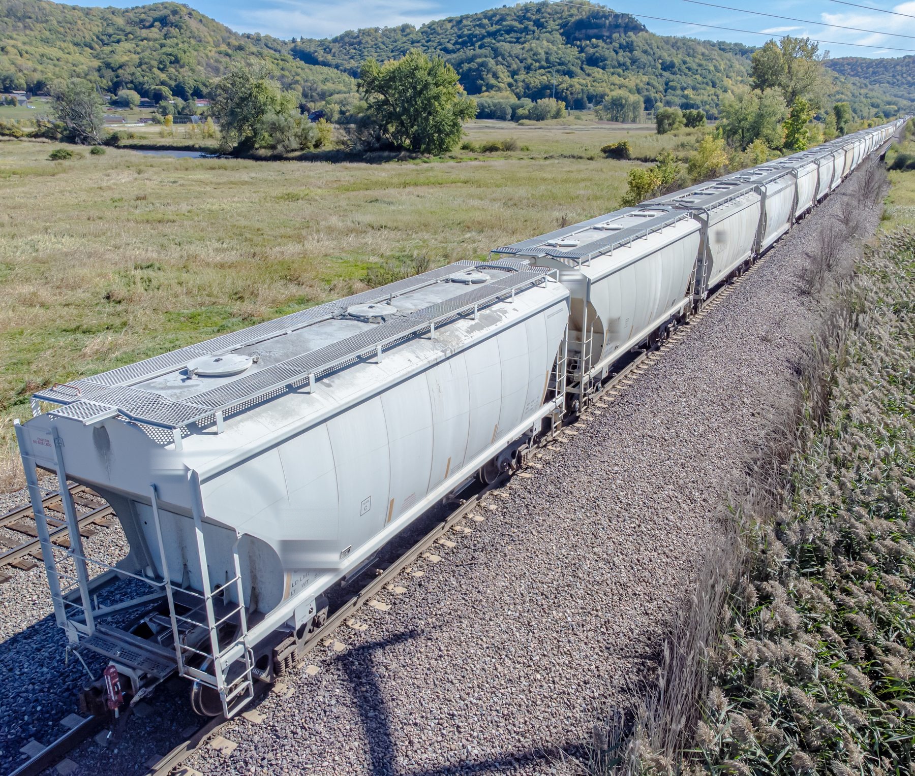 Covered hopper rail cars on prairie rail