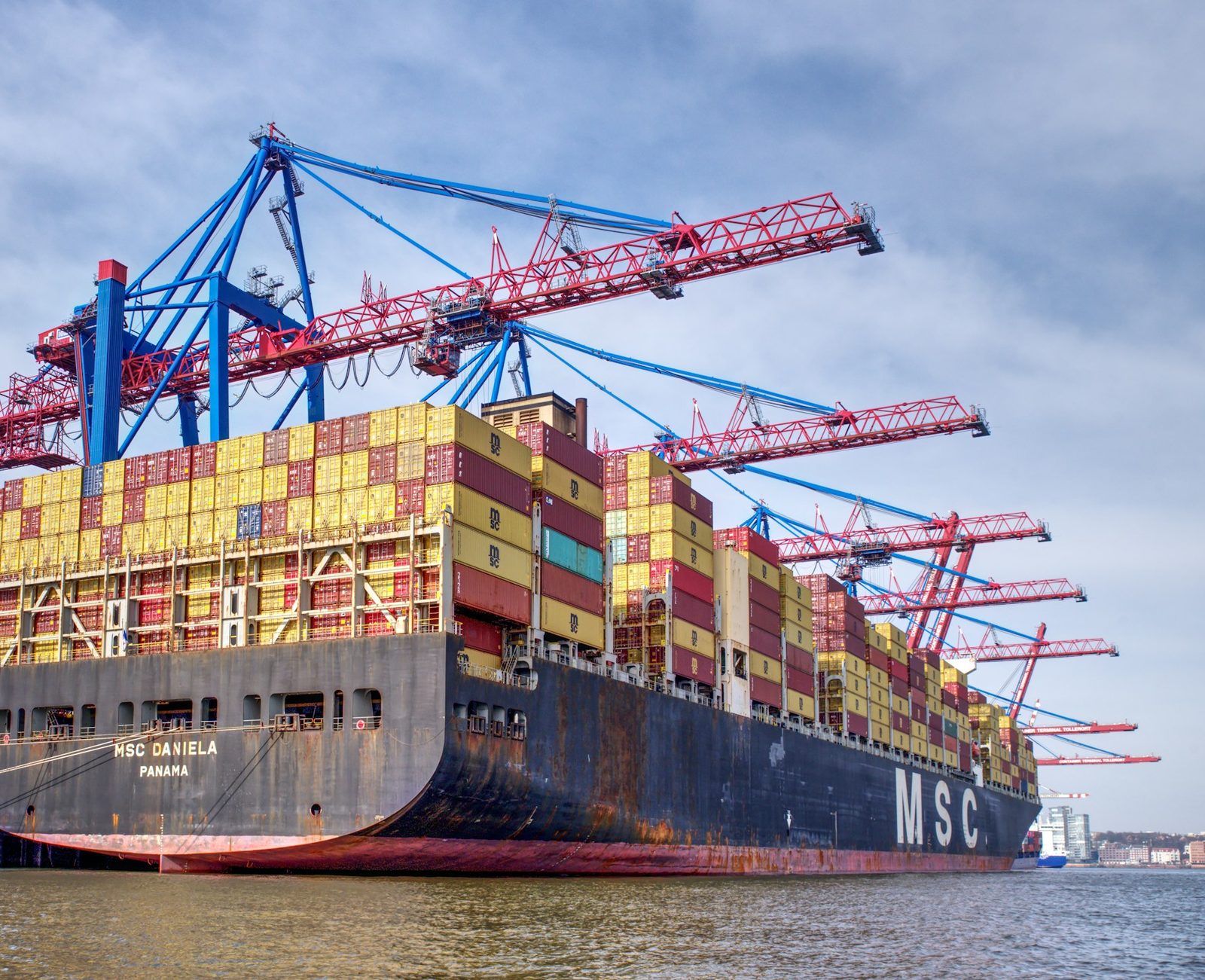 Container ship loading under port cranes